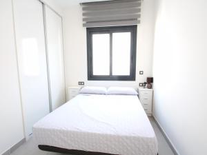 a white bedroom with a bed and a window at Designer Villa with pool in Torrevieja +5 photos