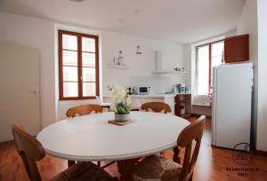 a kitchen with a white table and a white refrigerator at Chez Leopold et Anais au cœur d Albi in Albi