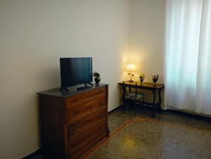 a living room with a television on a dresser with a table at Small Luxury House in La Spezia