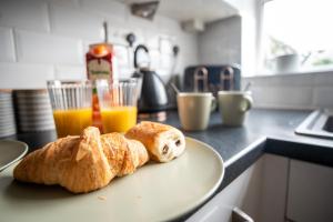 two croissants on a plate on a kitchen counter at Stunning Cardiff Wharf View 4 Bed Free Parking in Cardiff +54 photos