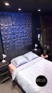 a bedroom with two beds and a blue wall at Vice City Expérience urbaine et romantique in Mons-en-Baroeul