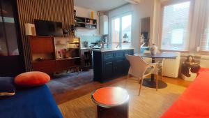 a living room with a table and a kitchen at La Madeleine de Nico in La Madeleine