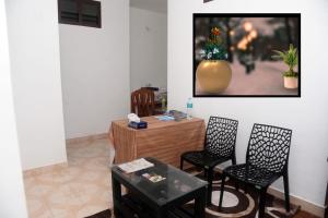 a living room with chairs and a vase on the wall at Crystal Palace Odayam in Varkala