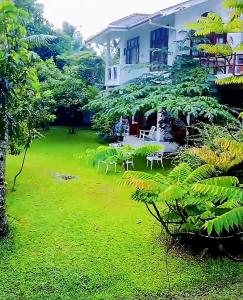 a lawn in front of a house with tables and chairs at GreenHeart- Family Room-Micro Apartment, AC- Hot W, Garden View, separate Varanda & Dining Area - Travel Awards 2025 in Maharagama
