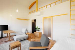 a living room with a bed a chair and a table at Passage LODGE Hakuba in Hakuba