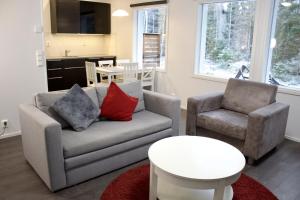 a living room with a couch and a chair and a table at Modern Slope Apartment in Vuokatti