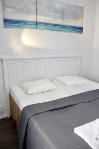 a bed with two pillows and a painting on the wall at Modern Slope Apartment in Vuokatti