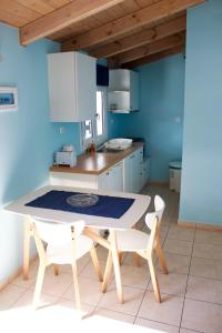 a kitchen with a white table and chairs in a room at Kekatos Studios in Lassi