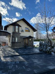 a large white house with a driveway at Cottage Zelman in Yaremche