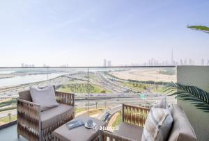 een balkon met stoelen en uitzicht op de stad bij Manzil - 1BR Apartment in Farhad Aziz Residence with Burj View in Dubai +11 foto's