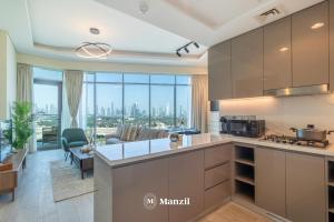 een keuken en een woonkamer met uitzicht op de stad bij Manzil - 1BR Apartment in Farhad Aziz Residence with Burj View in Dubai