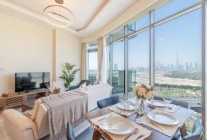een woonkamer met een tafel en een groot raam bij Manzil - 1BR Apartment in Farhad Aziz Residence with Burj View in Dubai