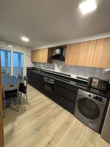 eine Küche mit einem Herd und einem Geschirrspüler in der Unterkunft Piso en Ribeira a 20metros de la playa de Coroso by Cristian&Tamara "alquileres" in Ribeira