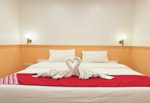 two towel swans sitting on top of a bed at Collection O The Singha Chiangmai Hotel in Chiang Mai