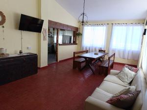 ein Wohnzimmer mit Sofa und Tisch in der Unterkunft Silencio Dorado in Villa Serranita