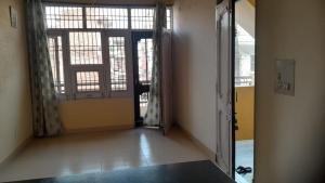 an empty hallway with two large windows and a door at Holy Hills Homestay in Zirakpur +4 photos