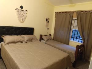 ein Schlafzimmer mit zwei Betten und einem Fenster in der Unterkunft Silencio Dorado in Villa Serranita + 13 Fotos