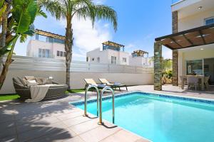 a swimming pool in the backyard of a house at Villa Anastasia - Fig Tree Bay Area in Protaras
