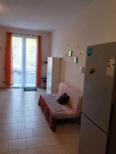 a kitchen with a refrigerator and a bed in it at La casa nella Valle in Monti di Licciana Nardi