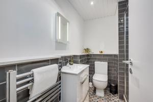 un baño con inodoro y lavabo en Belfast City apartment with free parking!, en Belfast 27 fotos más
