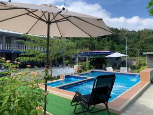 an umbrella and a chair next to a swimming pool at Lone Star Inn in san juan la union