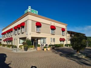 a building with a hotel with red awnings on it at Hotel Lenotel in Leno