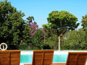 un par de sillas sentadas junto a una piscina en Quinta Dos Ribeiros, en Alpalhão