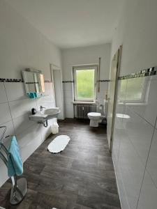 a bathroom with two sinks and a toilet and a window at Ferienhaus an der Saline in Bad Karlshafen