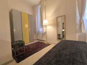 a bedroom with a bed and a mirror and a lamp at Maison Rebecca - Superior Suite Apartment in Ravenna