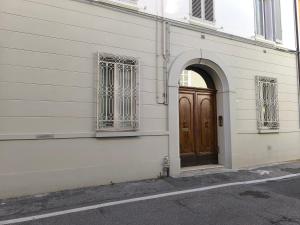 un bâtiment avec une porte en bois et une porte voûtée dans l'établissement Maison Rebecca - Superior Suite Apartment, à Ravenne
