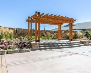 a wooden pergola in a garden with flowers at Big Horn Resort, an Ascend Collection Hotel in Billings