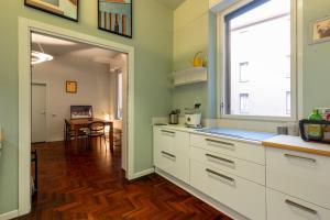 a kitchen with white cabinets and a large window at Cairoli Suite e Garage in Milan +18 photos