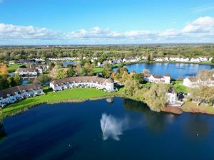 an aerial view of a home on a lake at Luxury Kingfisher Lodge, Isis Lake, within the Cotswold Waterpark in Cirencester