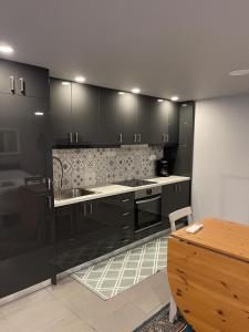 a kitchen with black cabinets and a sink at River Country Homes in Kalavrita