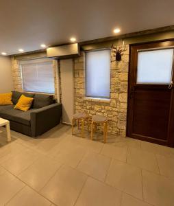 a living room with a couch and a stone wall at River Country Homes in Kalavrita