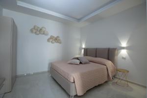 ein Schlafzimmer mit einem Bett in einem weißen Raum in der Unterkunft Residence BLANCO GARDEN 1 a 100 mt dalla spiaggia di Posto Vecchio Marina di Pescoluse in Marina di Pescoluse