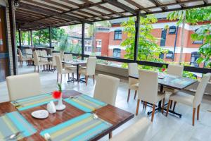a dining room with tables and chairs on a balcony at Heri Heights Hotel Apartments, SureStay Collection by Best Western in Nairobi