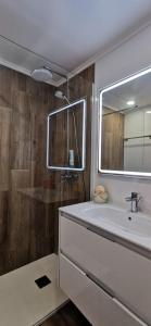 a bathroom with a tub and a sink and a mirror at Apartamento Varanda do Sol in Monte Gordo