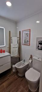 a white bathroom with a toilet and a sink at Apartamento Varanda do Sol in Monte Gordo +20 photos