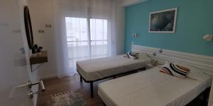 a room with two beds and a window at Apartamento Varanda do Sol in Monte Gordo
