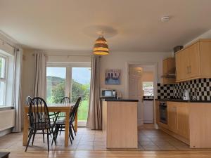 a kitchen with a table and chairs and a dining room at Doolin Village Lodges in Doolin