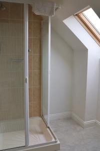 a shower with a glass door in a bathroom at Doolin Village Lodges in Doolin