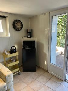 a kitchen with a refrigerator and a clock on the wall at Chambre avec terrasse in Fréjus