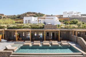 a villa with a swimming pool and a house at Mileo Mykonos in Kalo Livadi
