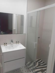 a white bathroom with a sink and a shower at Love Room Sensuelle in Tremblay En France