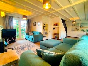 a living room with blue couches and a tv at Tudor Cottage Hayle - a Family & Dog Favourite in Hayle