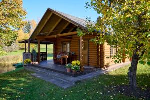 a log cabin with a porch and a table at Anni Saunamaja in Meeliku