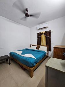 巴加Rosy Guest House since 1989的带床和吊扇的卧室