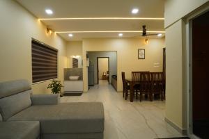 a living room with a couch and a dining room at Elephant Village Private Pool Villa in Munnar