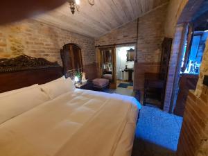 a bedroom with a large bed in a brick wall at The Stables in Riebeek-Wes